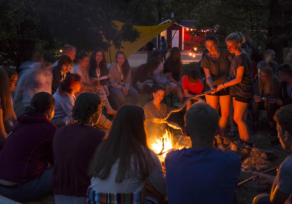 Jugendliche am Lagerfeuer Abends kannst du bei Stockbrot mit Blick in den Sternenhimmel am Lagerfeuer chillen.